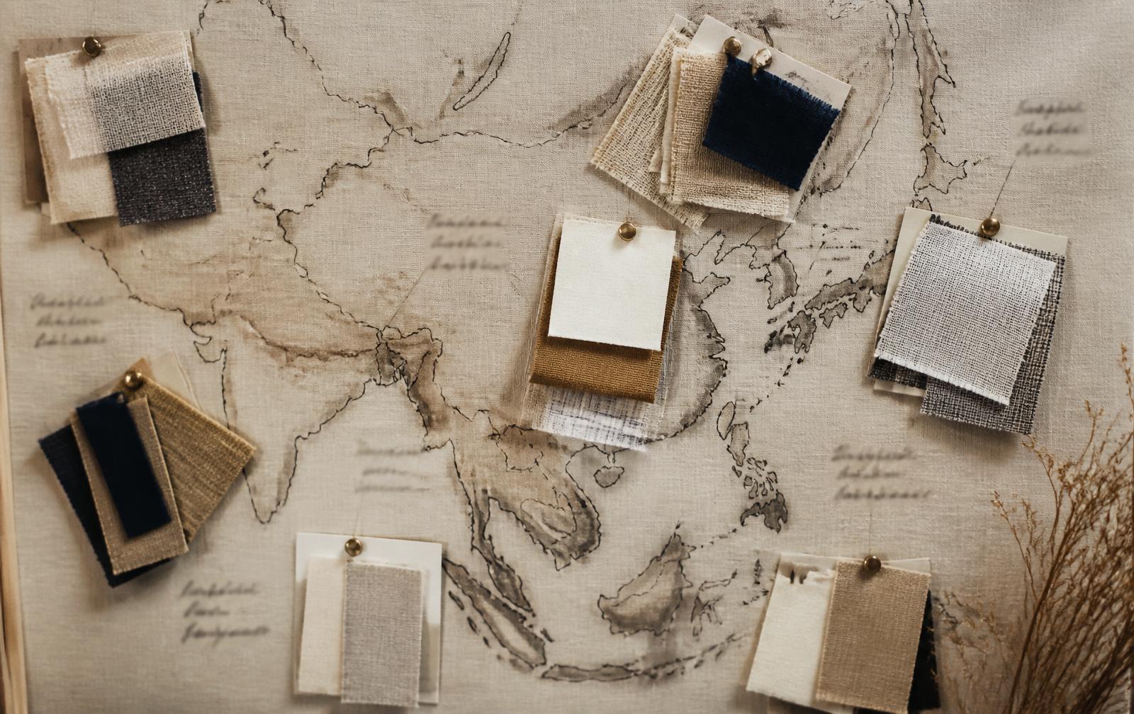Fabric swatches from Asian mill regions pinned to a linen board